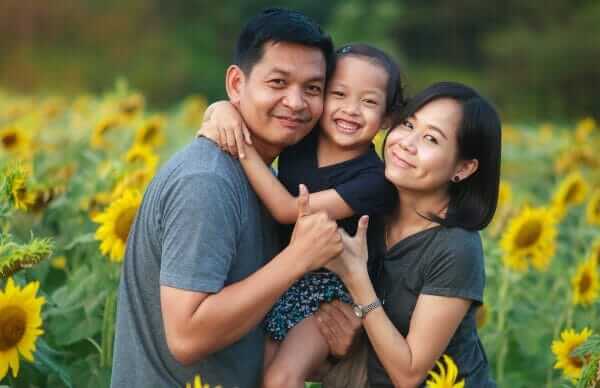 Asian family in field of sunflowers