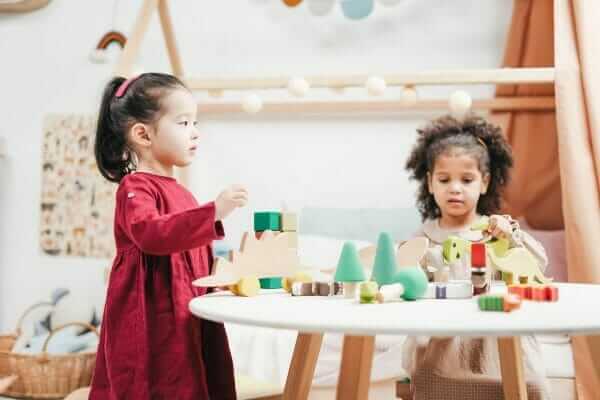 Two young girls playing blocks